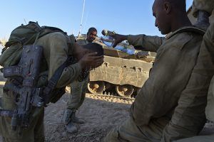 ISR05. SDEROT (ISRAEL), 21/08/2014.- Un grupo de soldados israelíes descansan junto a un tanque en un lugar sin localizar de la frontera de Israel con la Franja de Gaza hoy, jueves 21 de agosto del 2014. Las "Brigadas Azedim al Kasem", brazo armado de Hamás, prometieron hoy vengar la muerte de tres de sus comandantes, alcanzados esta madrugada por disparos de la aviación de guerra israelí contra un edificio de la ciudad de Rafah, en el sur de Gaza. En un comunicado difundido a través de la página web, la milicia palestina asegura que Israel "pagará un enorme precio por el asesinato" de Muhamad Abu Shamala, Raed al-Attar, Mohamad Barhum y otras cinco personas. EFE/Jim Hollander